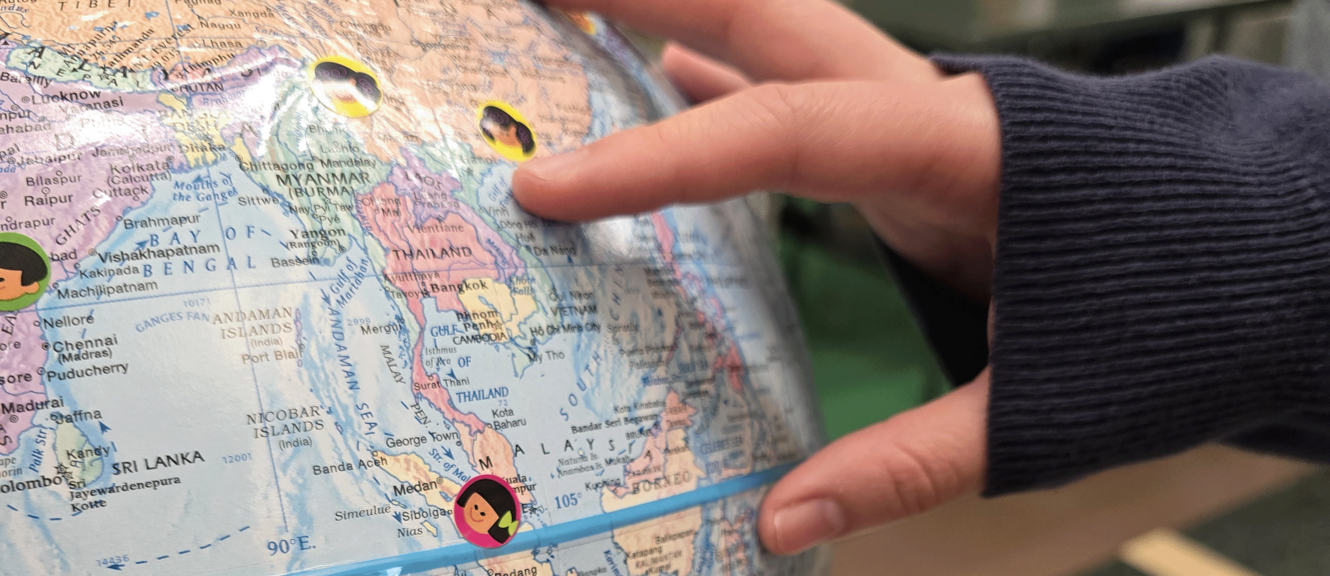 Student points to a place on the globe they feel connected to